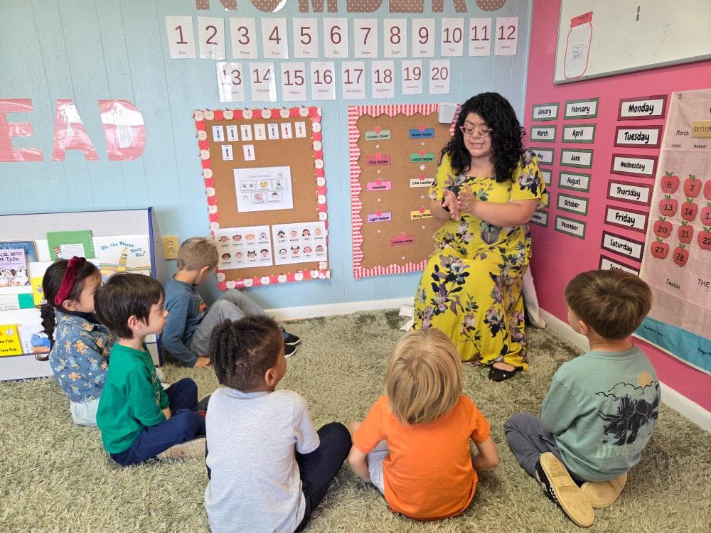 A teacher leading circle time with preschoolers on the classroom rug